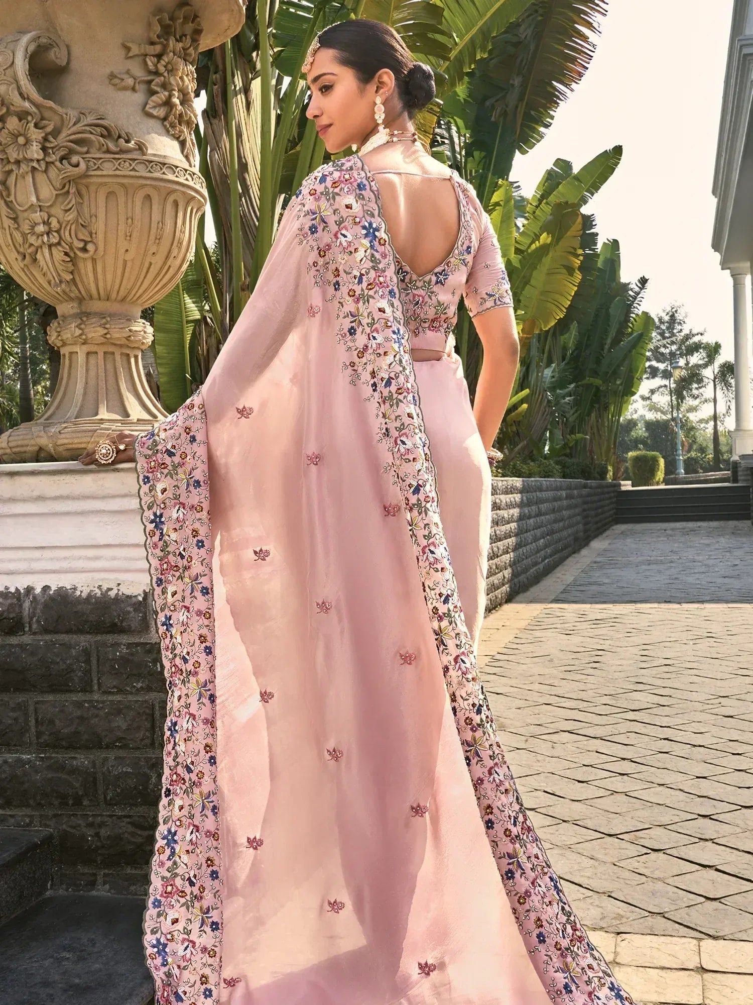 Elegant pink floral embroidered saree with open back design, perfect for Indian ethnic wear occasions.
