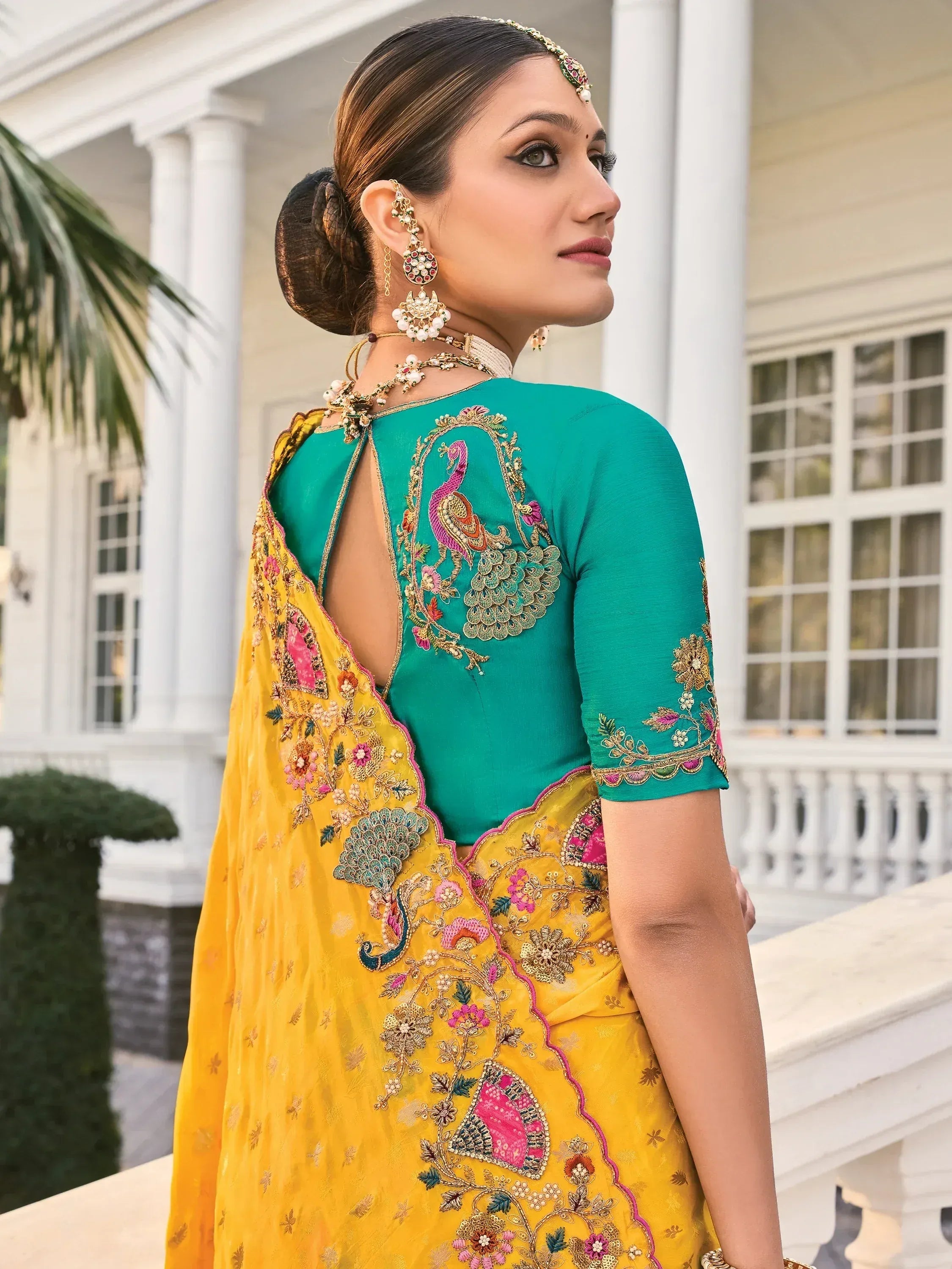 Elegant teal and yellow ethnic saree with peacock embroidery and back cutout design