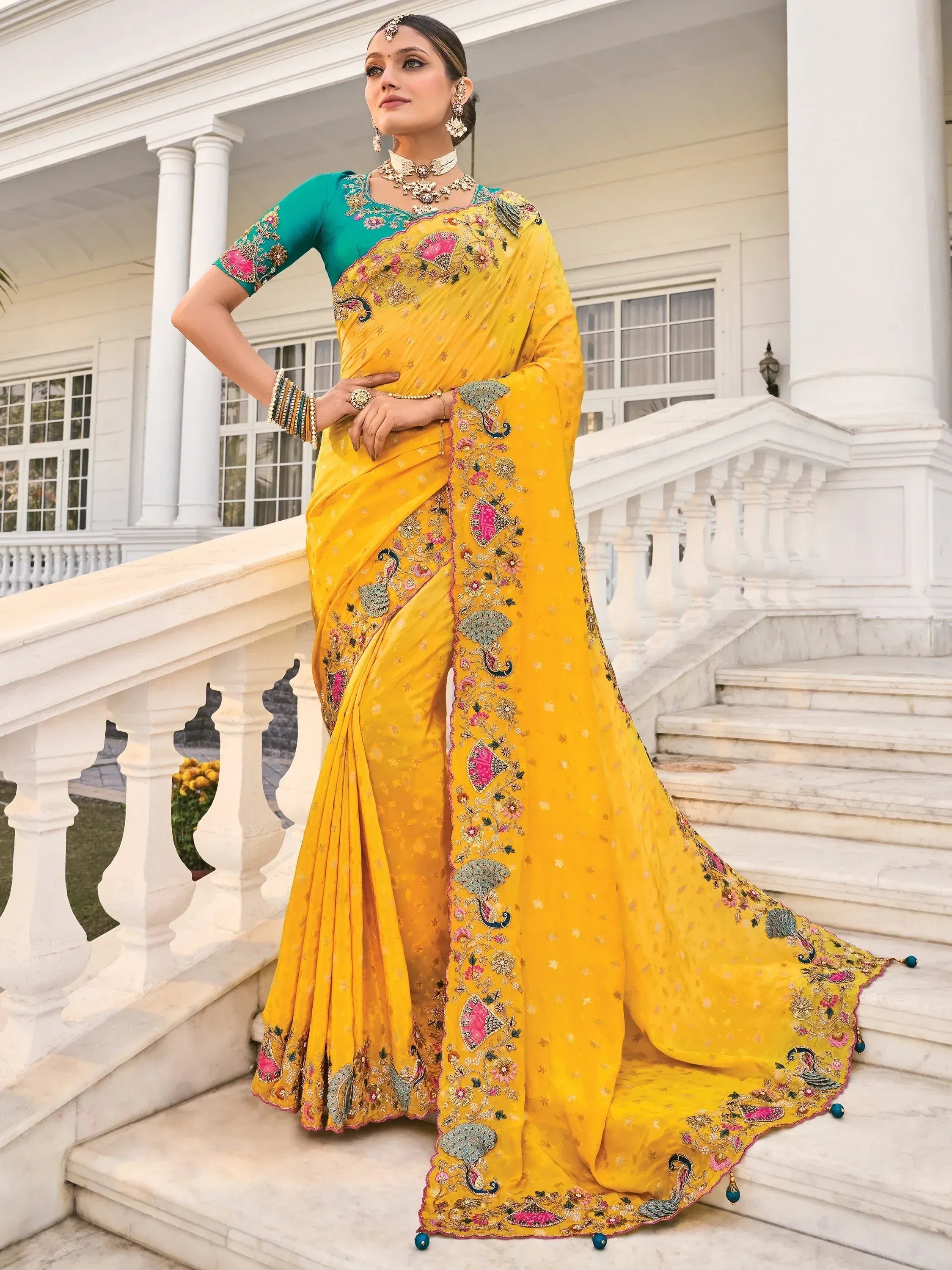 Yellow embroidered saree with peacock motifs, paired with teal blouse, ideal for Indian ethnic wear.