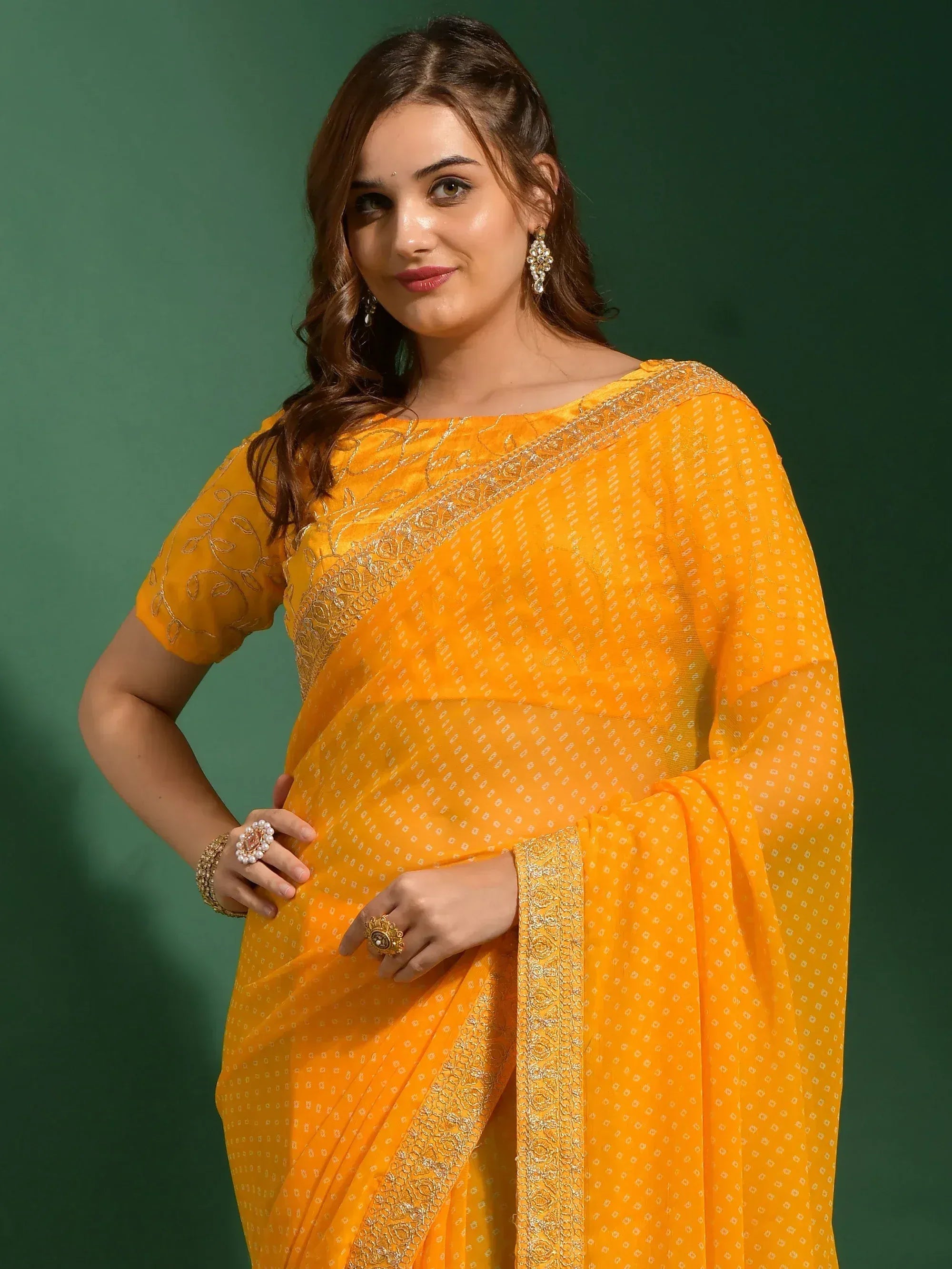 Vibrant yellow saree with gold embroidery and printed motifs, styled with traditional jewelry for ethnic wear.