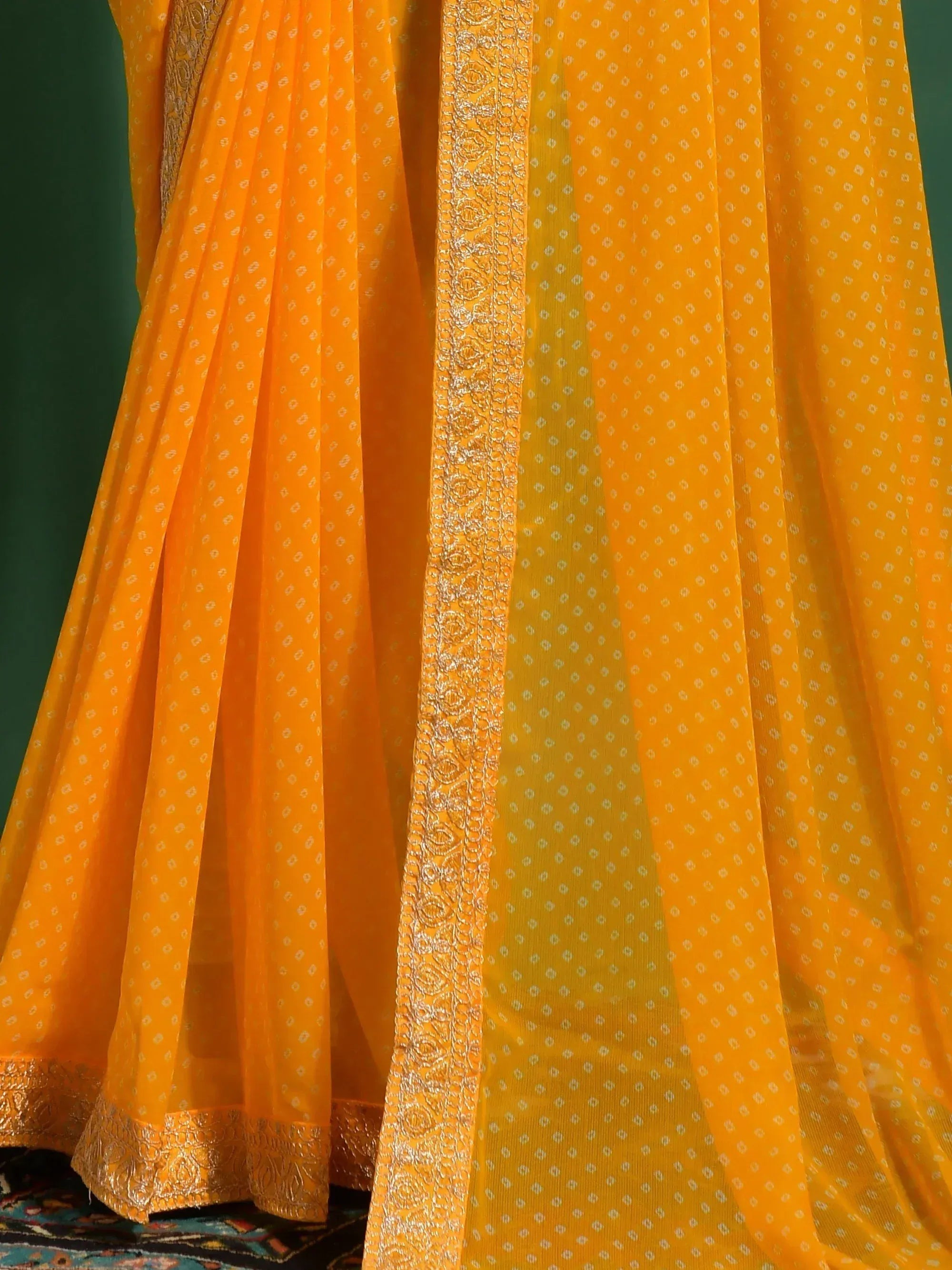 Vibrant yellow ethnic saree with gold embroidery and delicate dot pattern, perfect for festive occasions.