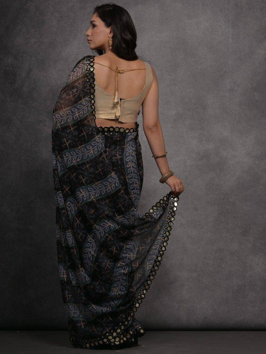 Woman in black printed saree with gold mirror work and backless blouse, ethnic Indian wear