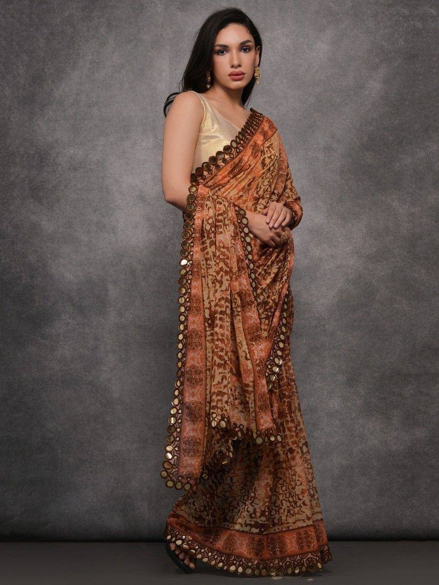 Elegant brown printed saree with gold mirror work and sleeveless blouse, perfect for ethnic occasions