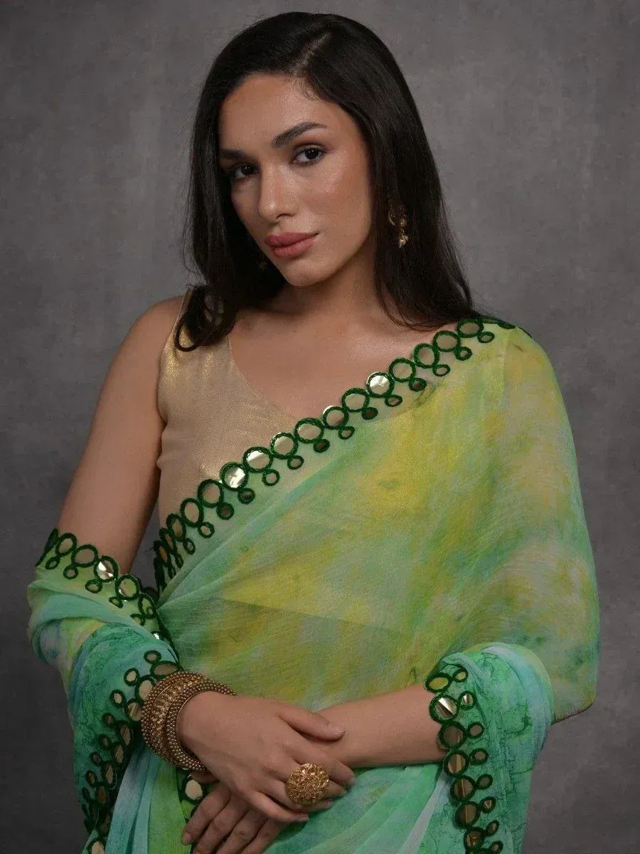 Green and yellow tie-dye saree with mirror work, paired with gold blouse for Indian ethnic wear