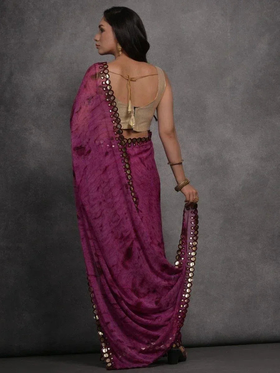 Purple ethnic saree with mirror work border and gold blouse, styled for Indian occasions