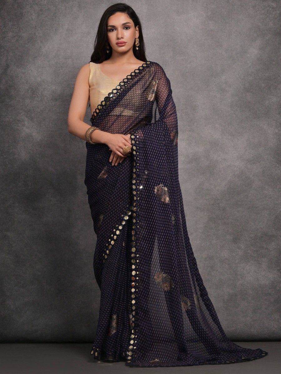 Elegant navy blue saree with gold embellishments and sheer overlay, paired with a golden blouse.