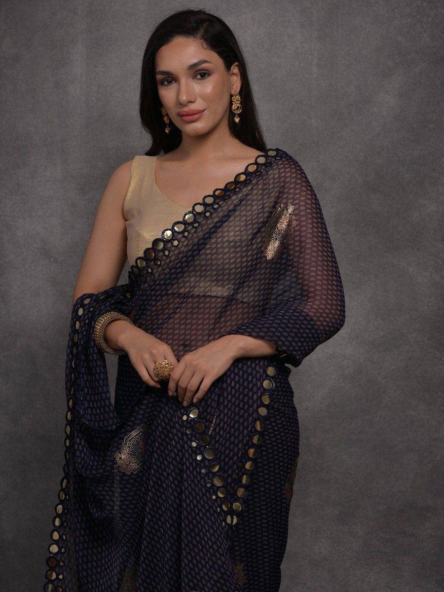Woman in navy blue designer saree with gold mirror work and sheer blouse, ethnic Indian wear