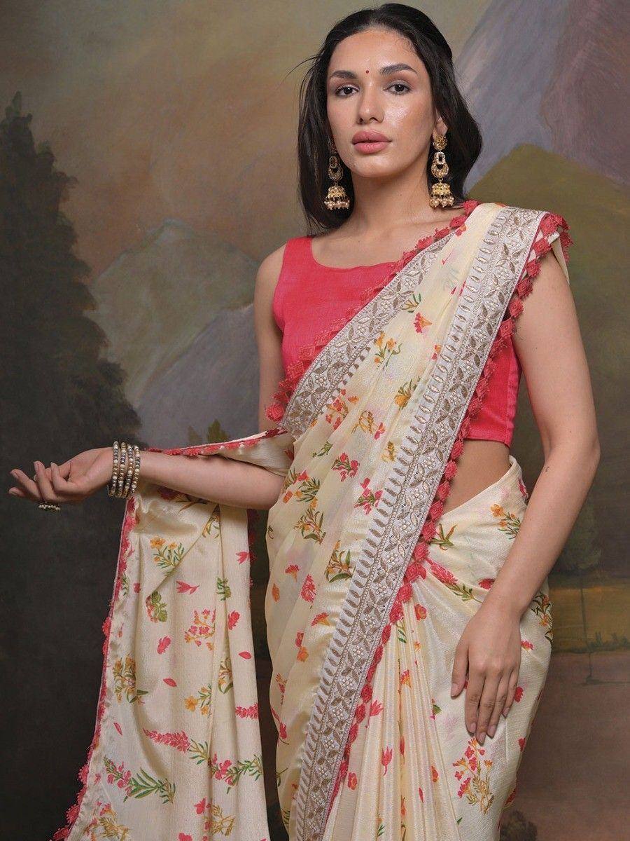 Floral print saree with embroidered border and pink blouse, styled with gold jhumka earrings for ethnic wear