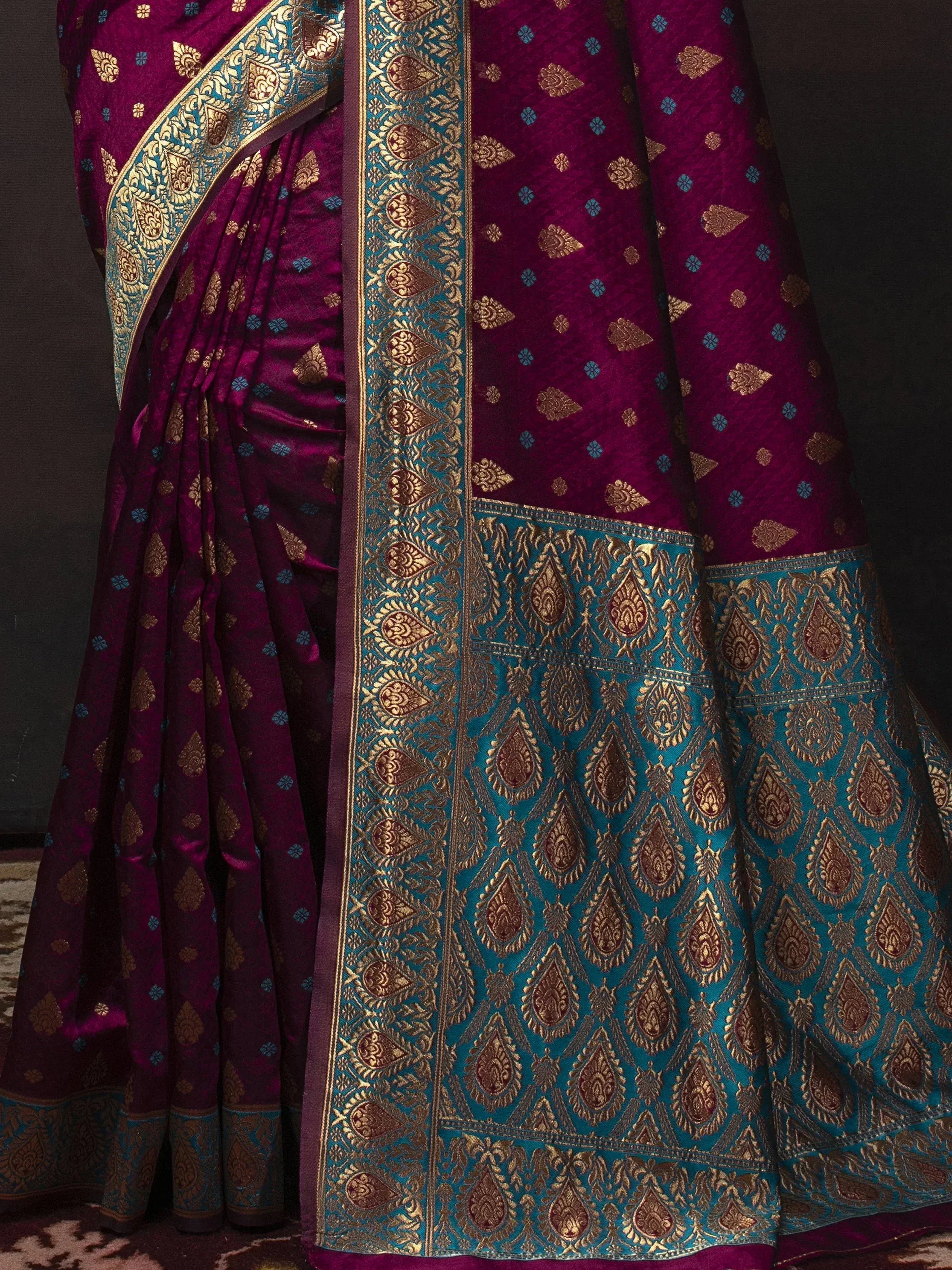 Rich purple and teal designer saree with intricate gold zari work, perfect for ethnic occasions.