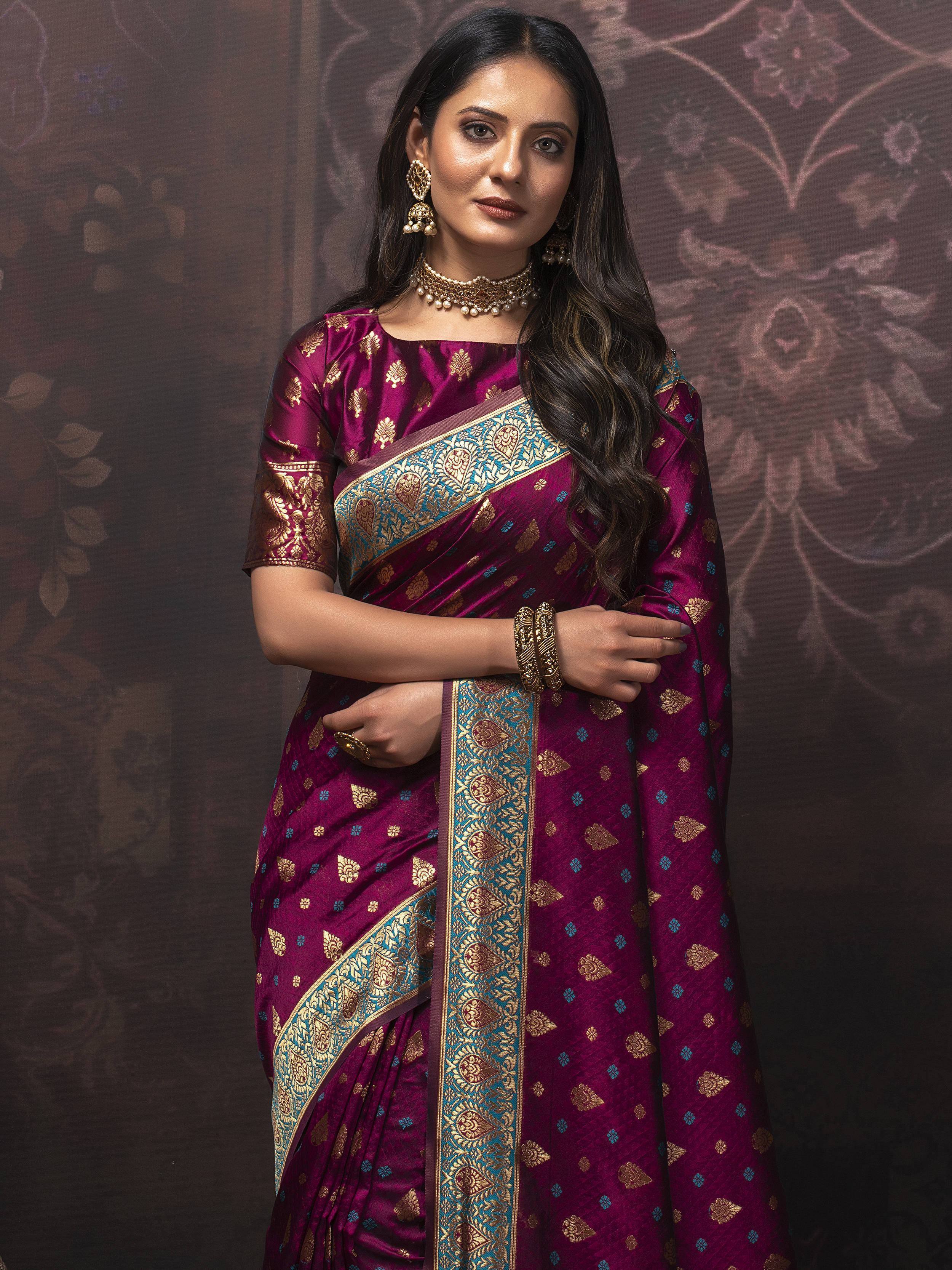Woman in elegant maroon silk saree with gold and blue zari work, perfect for Indian ethnic occasions.