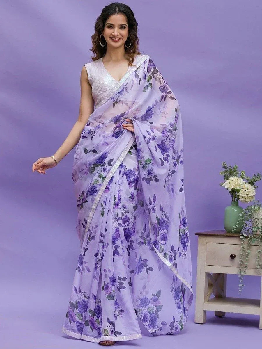 Woman in purple floral print saree with silver border, styled with sleeveless blouse for ethnic wear