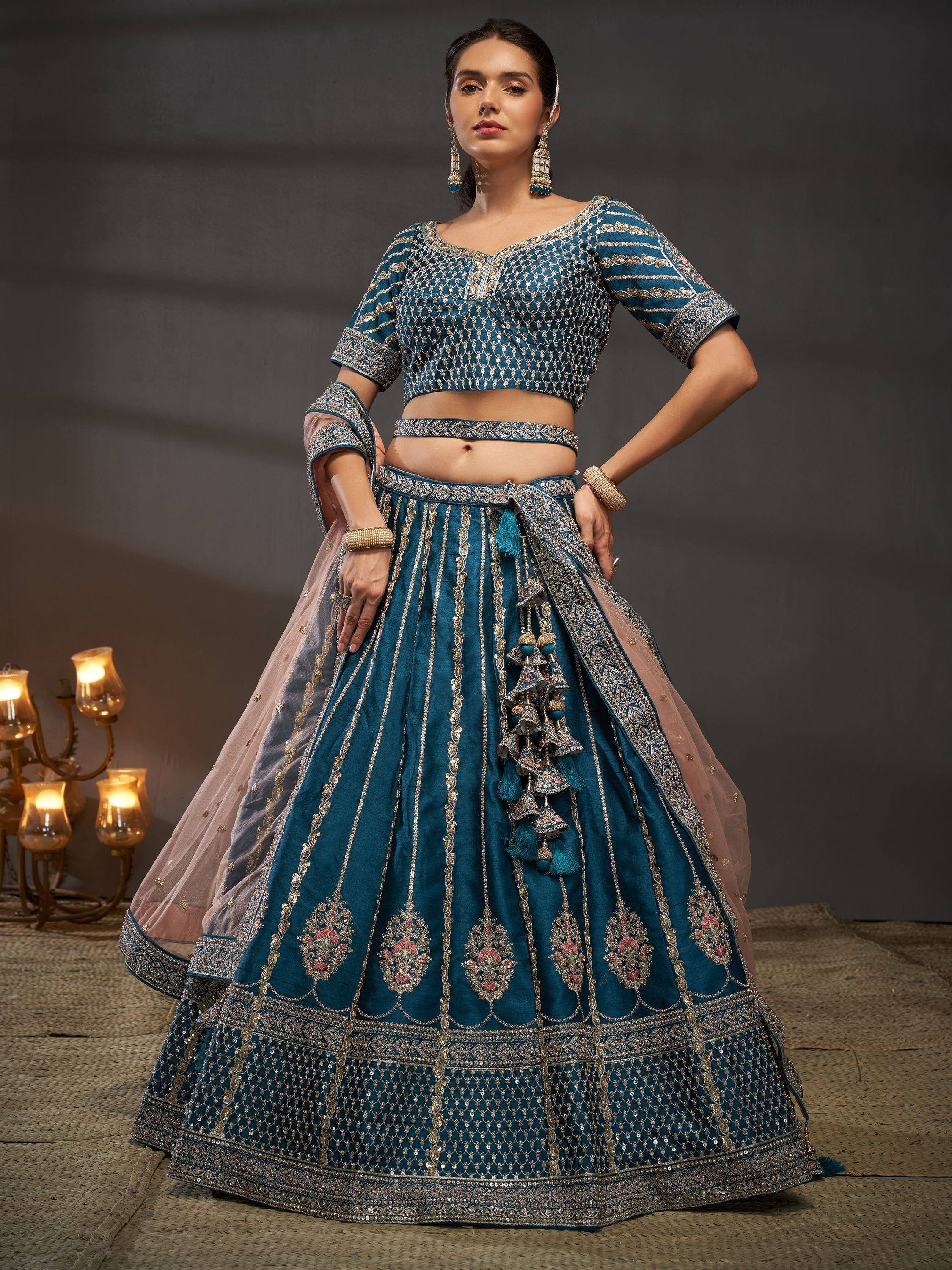 Teal blue designer lehenga choli with gold embroidery and tassels, perfect for Indian weddings and festivals