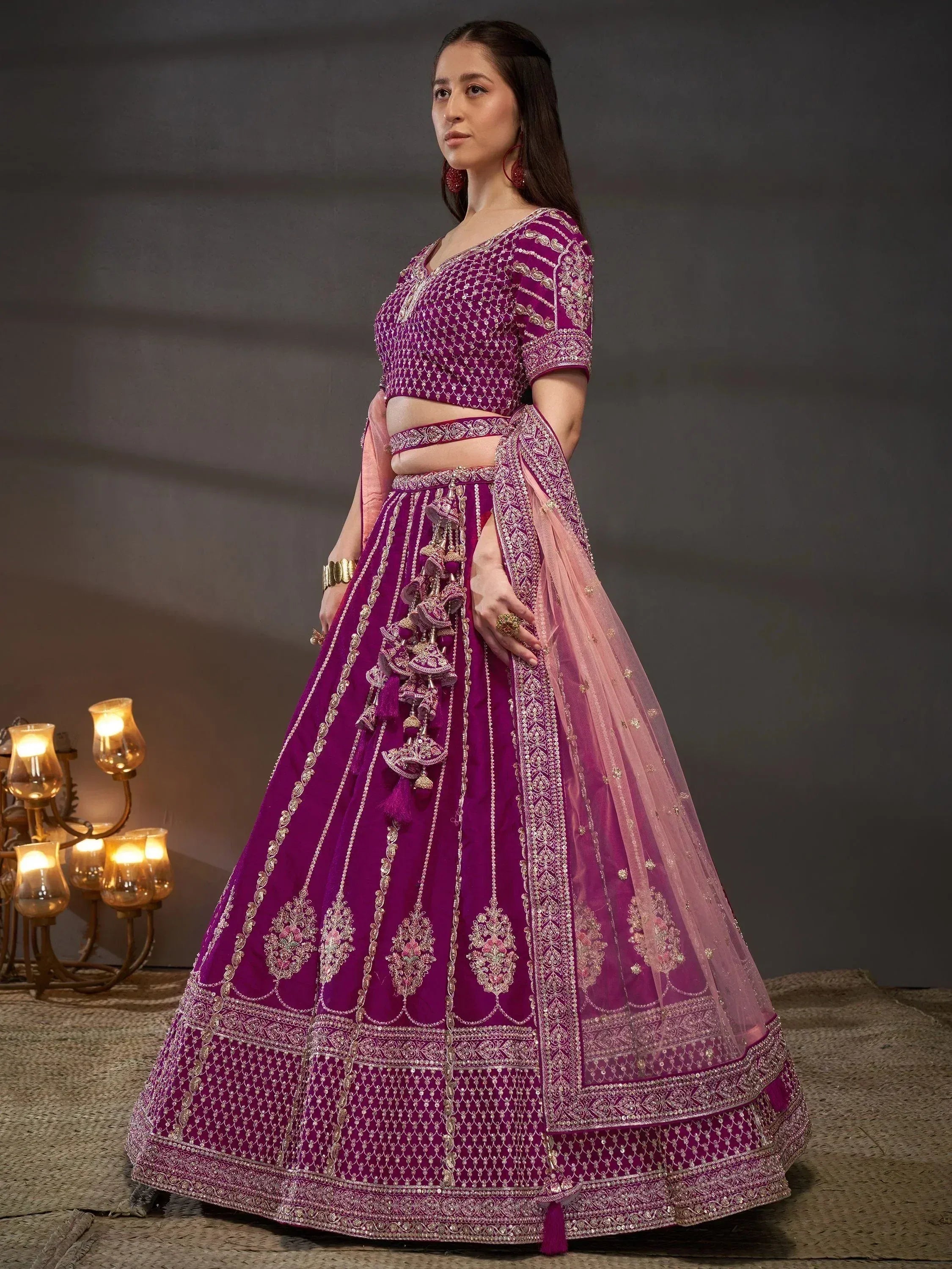 Elegant purple lehenga choli with intricate gold embroidery and tassels, perfect for Indian ethnic wear.