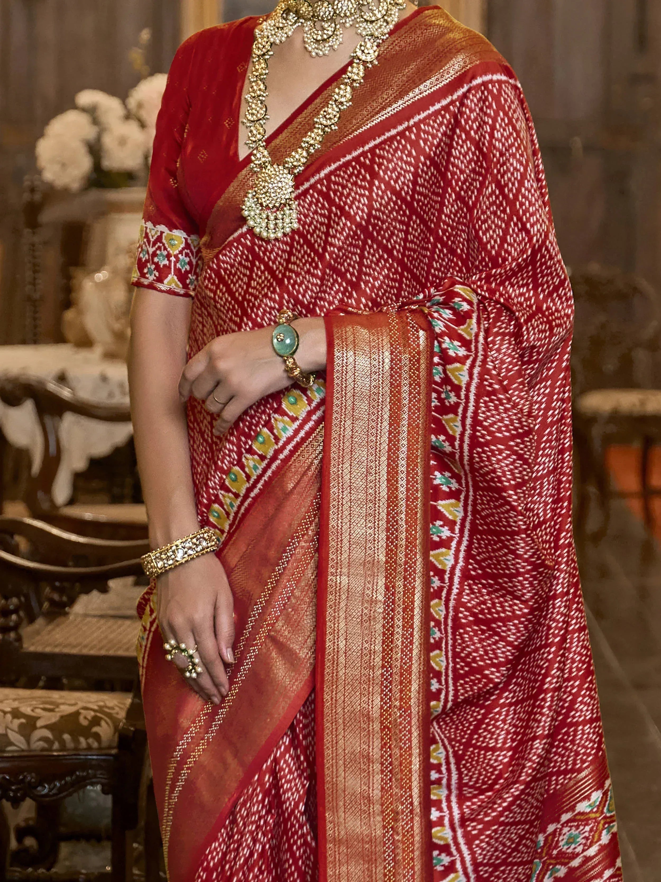 Red ethnic saree with gold border and traditional jewelry, perfect for Indian weddings or festivals