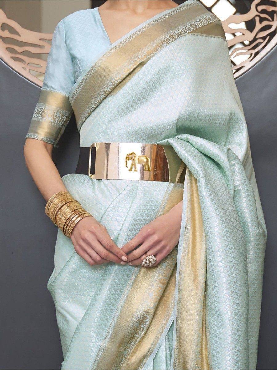 Mint green designer saree with gold border, elephant belt, and ethnic jewelry for festive occasions