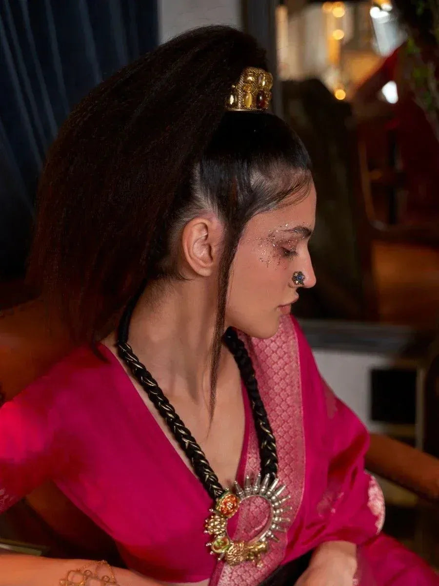 Woman in vibrant pink ethnic gown with gold hair accessory and traditional jewelry