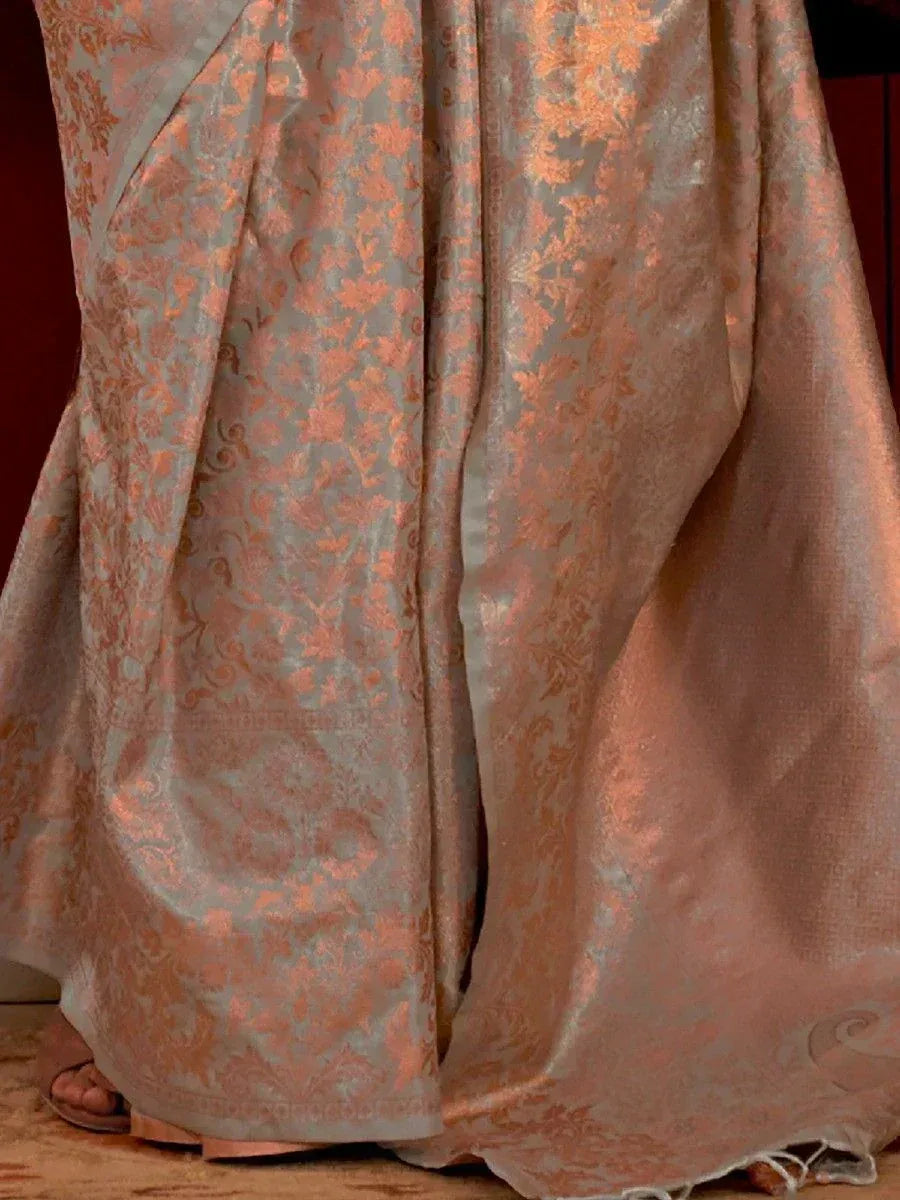 Elegant peach and silver brocade saree with floral motifs, perfect for Indian ethnic wear occasions.