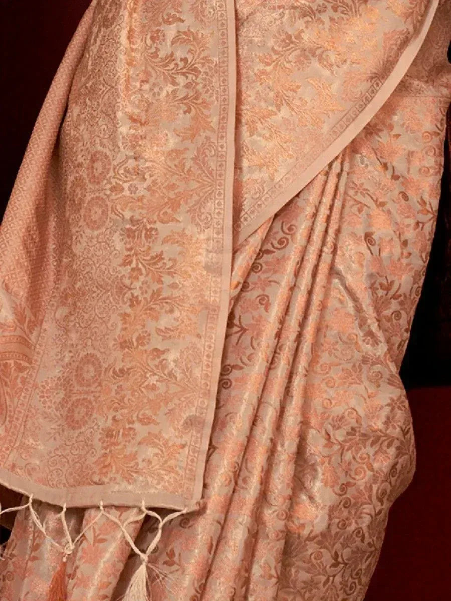 Elegant peach designer saree with intricate floral jacquard pattern and tassel border