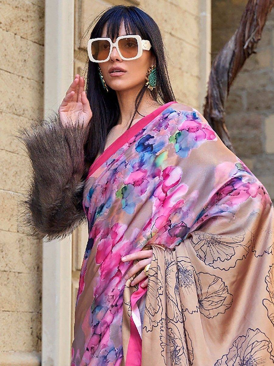 Woman in floral printed saree with pink border, wearing white sunglasses and statement earrings, posing outdoors.