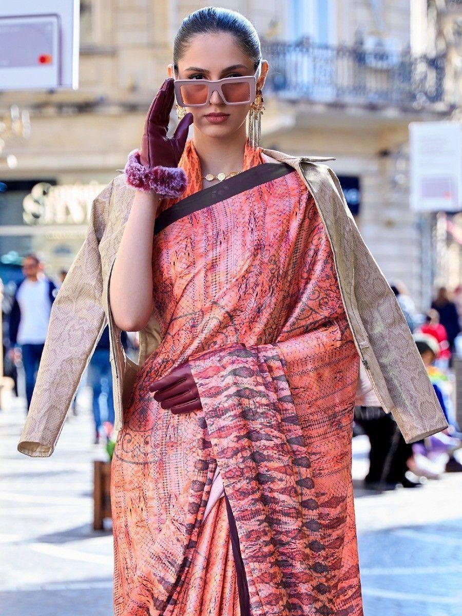 Woman in orange printed saree with gold jacket, stylish sunglasses, and gloves, street fashion look