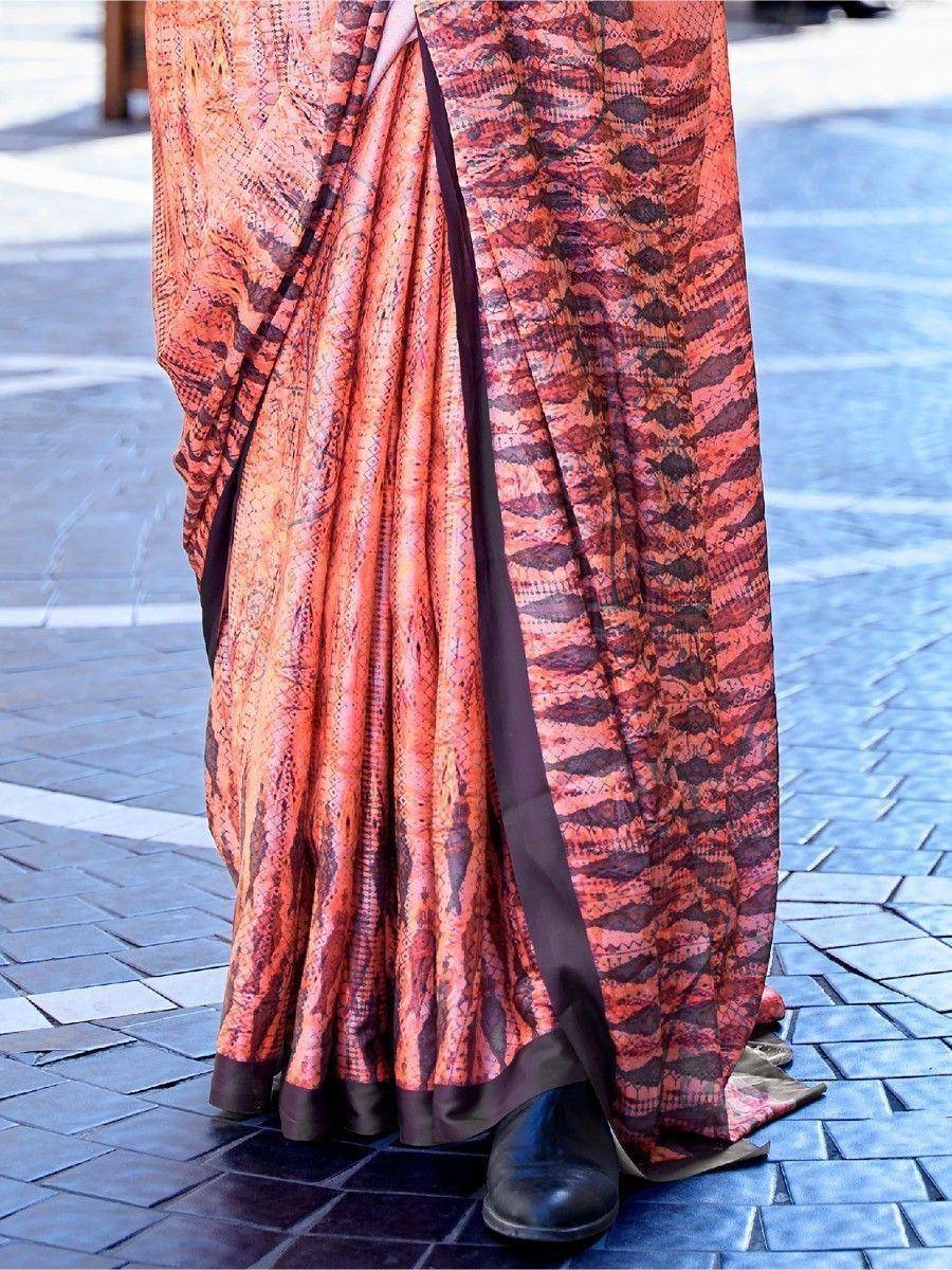 Orange and brown patterned ethnic saree with pleats, worn on paved street