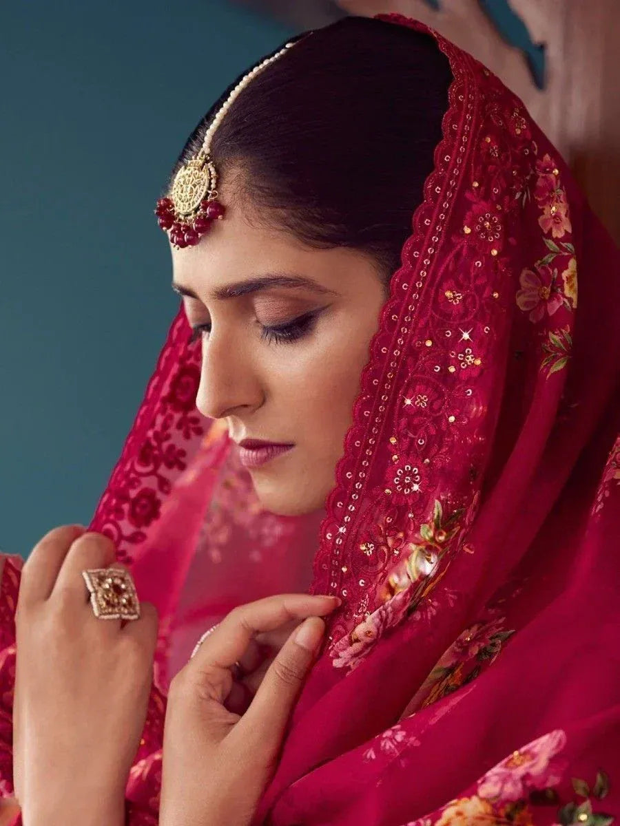 Woman in red floral ethnic dupatta with gold jewelry, showcasing traditional Indian bridal wear