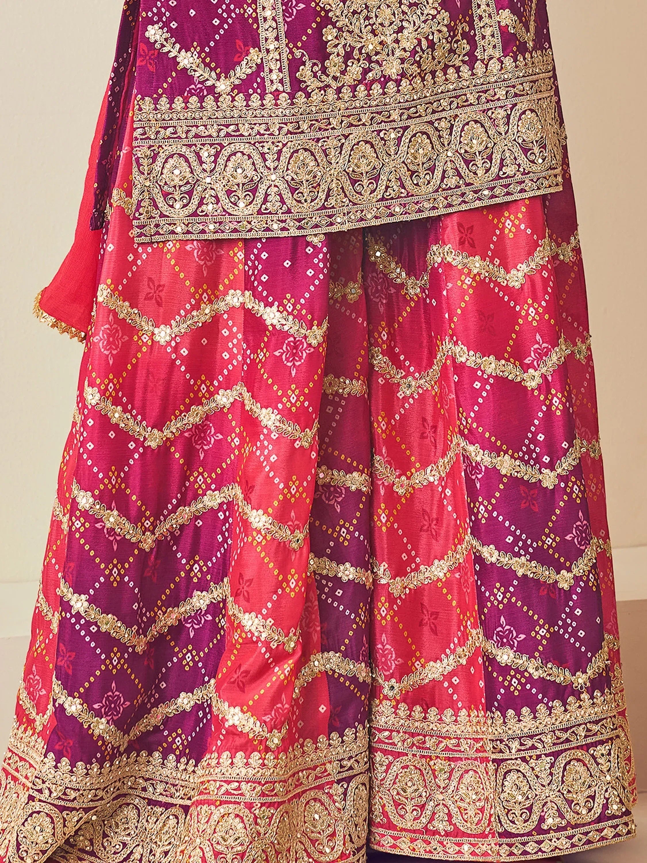 Elegant pink and purple lehenga choli with gold embroidery and intricate patterns