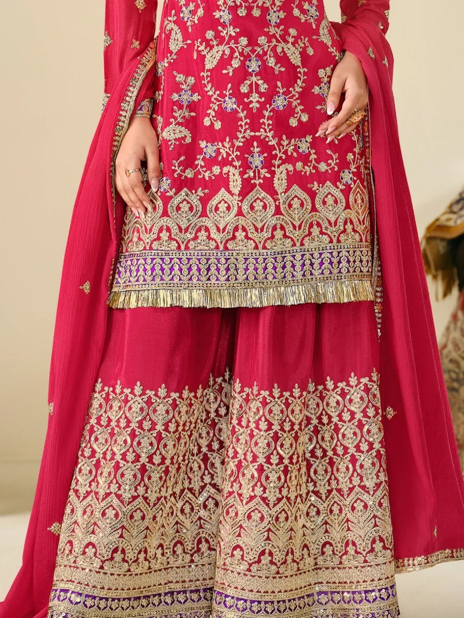 Red embroidered Indian salwar kameez with gold and purple detailing, perfect for festive occasions