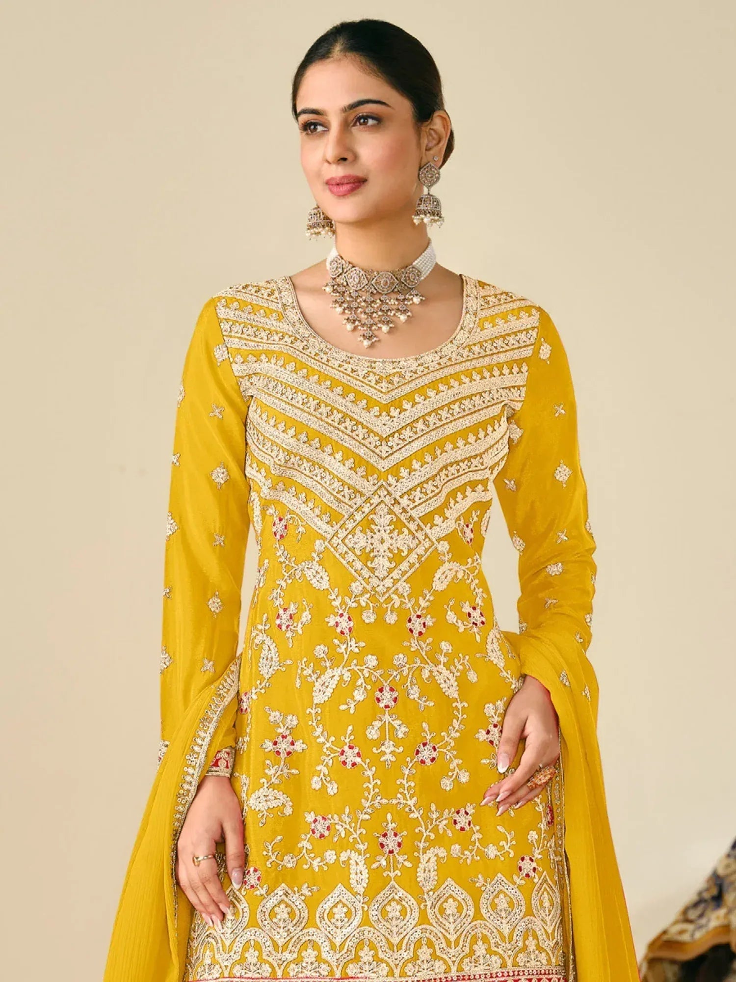 Yellow embroidered Indian ethnic salwar kameez with floral motifs and traditional jewelry