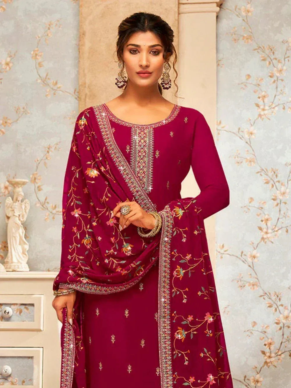 Woman wearing maroon embroidered salwar kameez with floral dupatta in an ethnic style