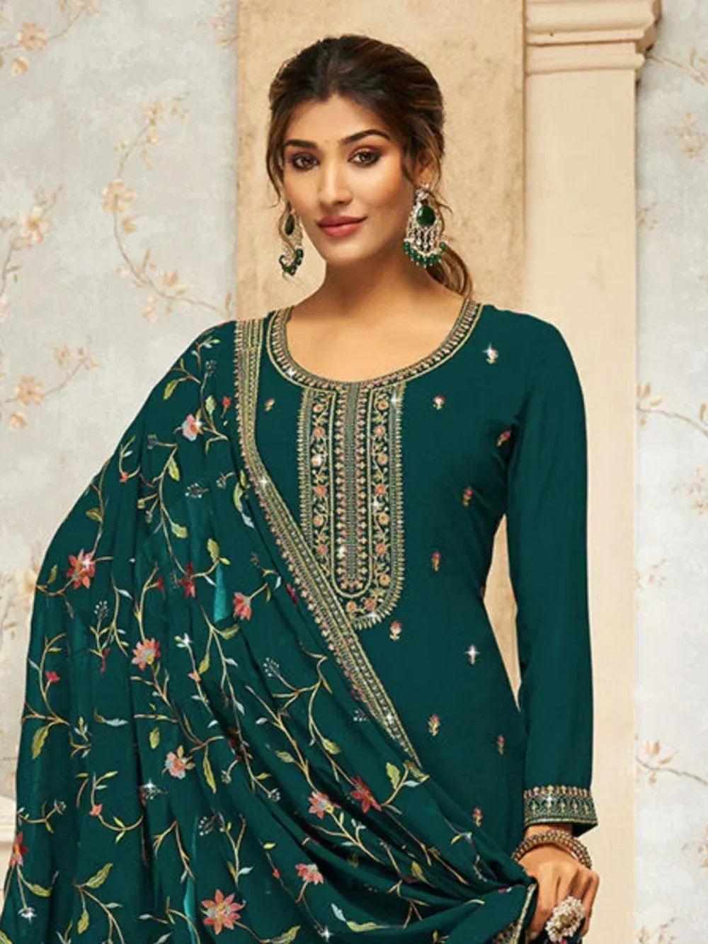 Woman wearing dark green embroidered salwar kameez with floral dupatta and jewelry