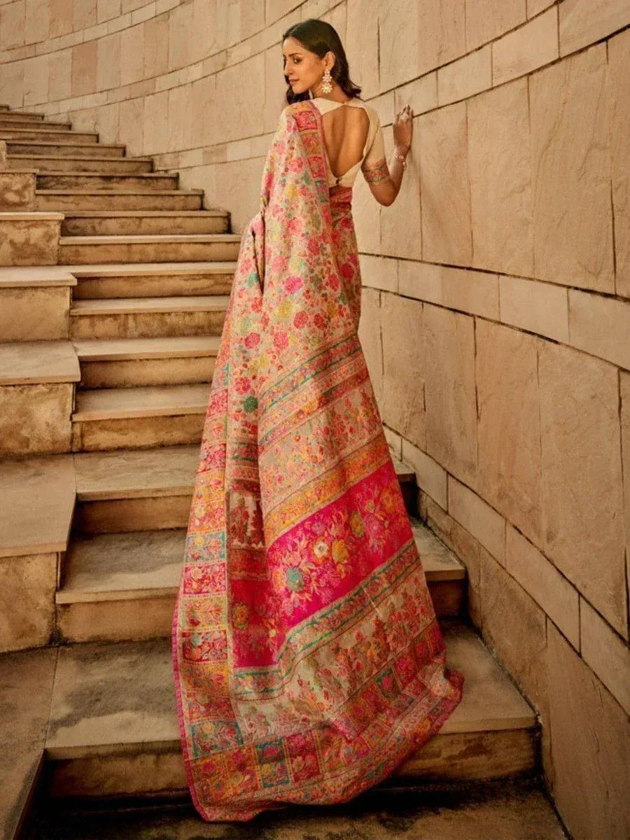 Woman in floral printed Indian saree with backless blouse, standing on stone stairs