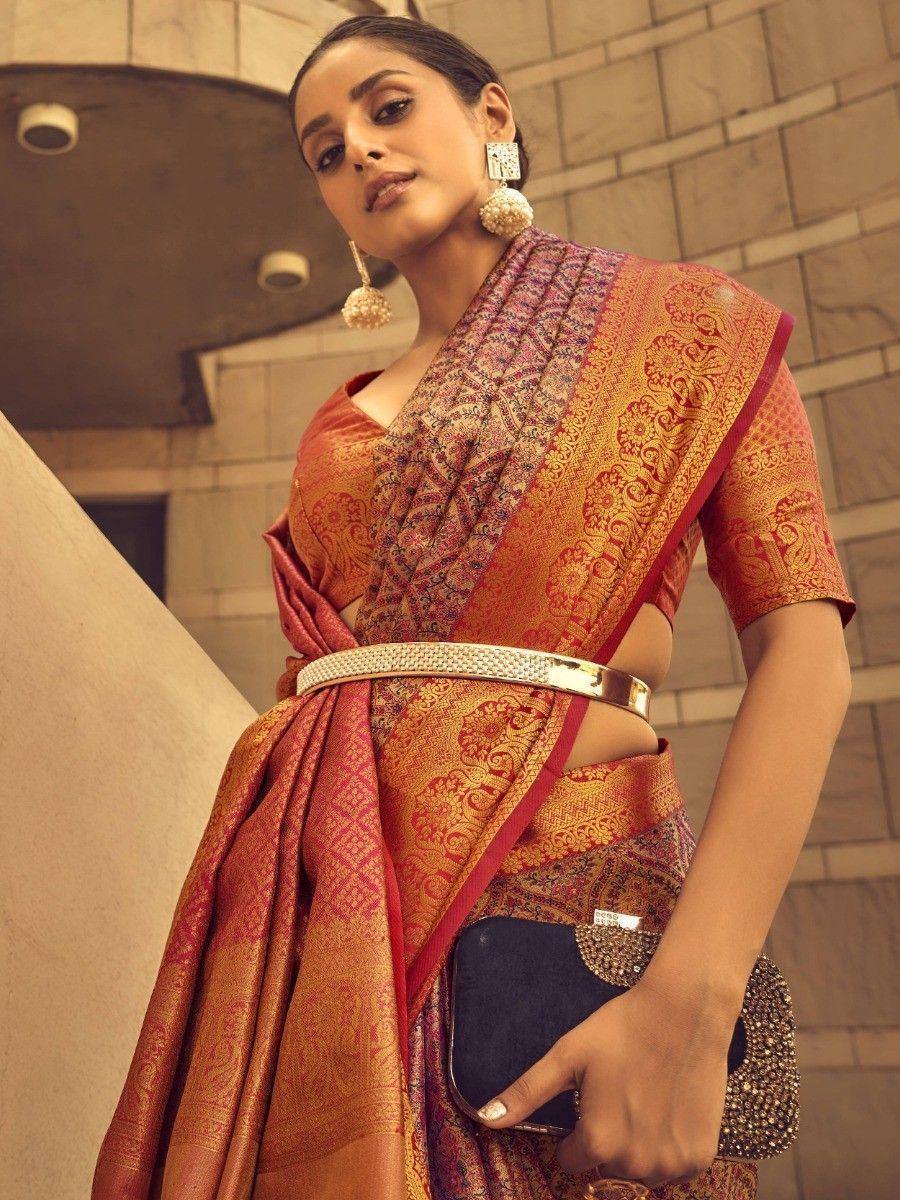 Woman in designer saree with gold embroidery, statement earrings, and embellished clutch for ethnic occasions