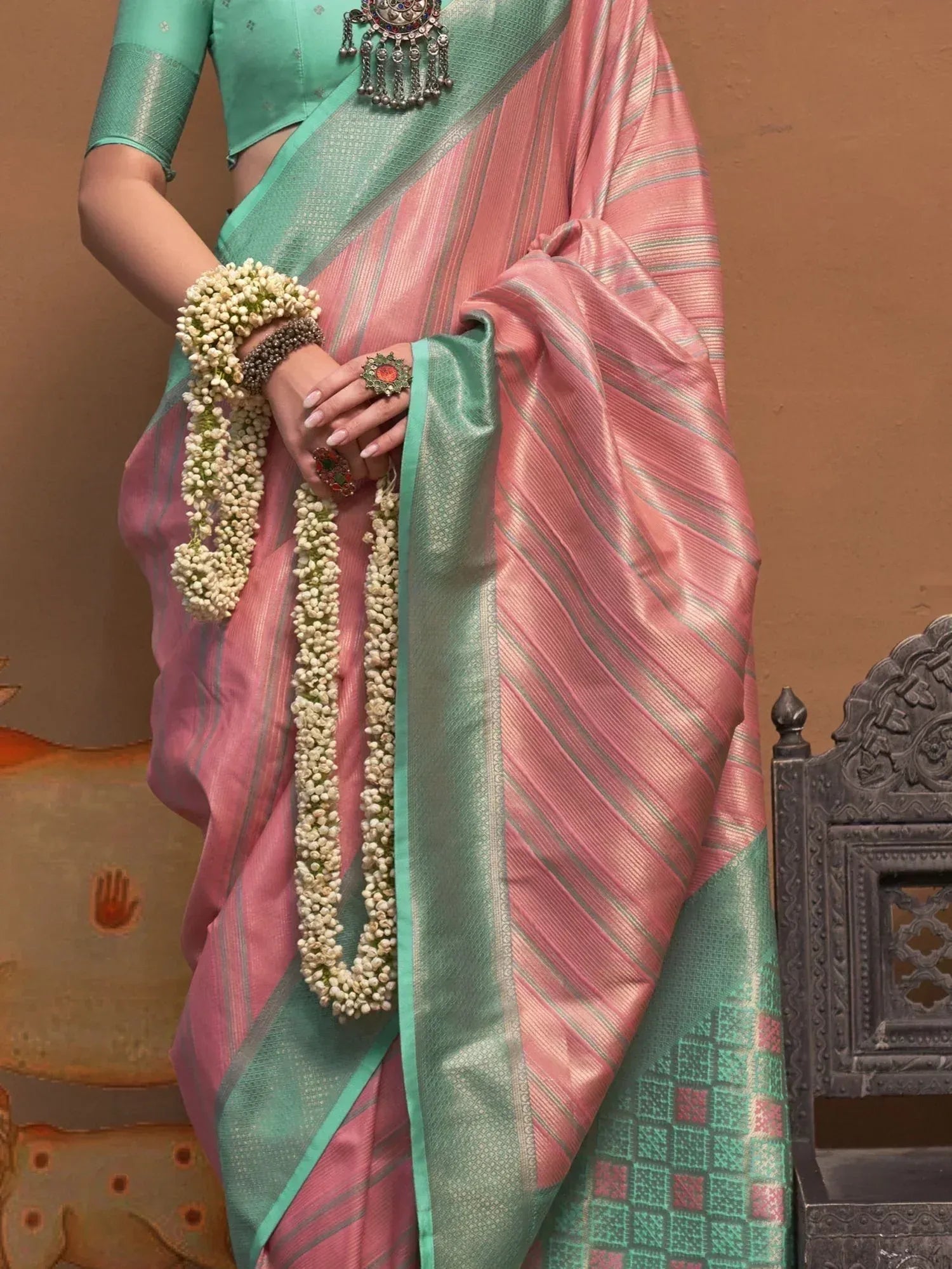 Pink and mint green striped saree with floral garland, traditional Indian ethnic wear