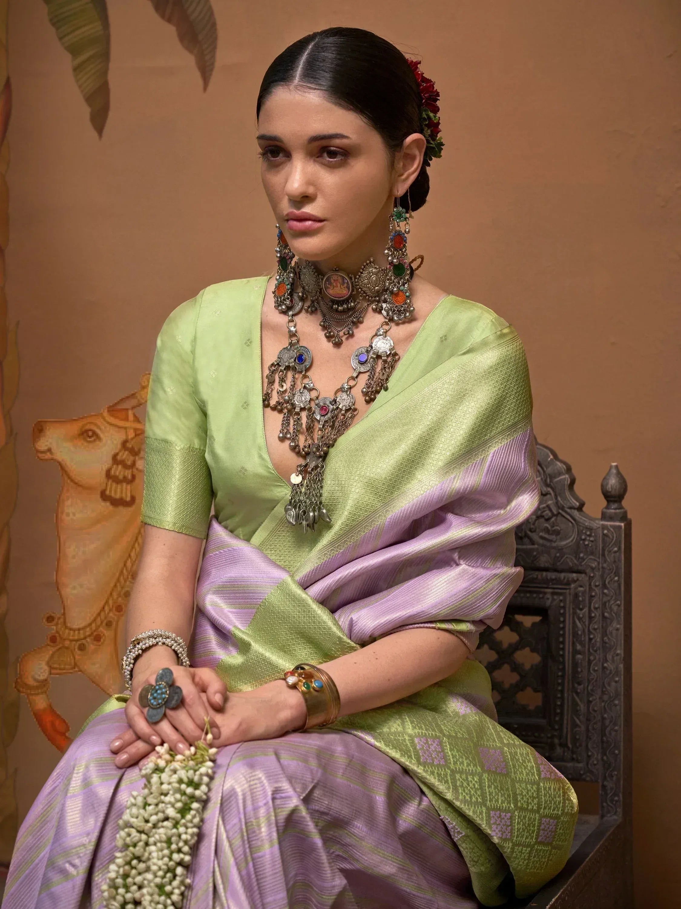 Woman in elegant green and lavender saree with traditional Indian jewelry, perfect for ethnic occasions.