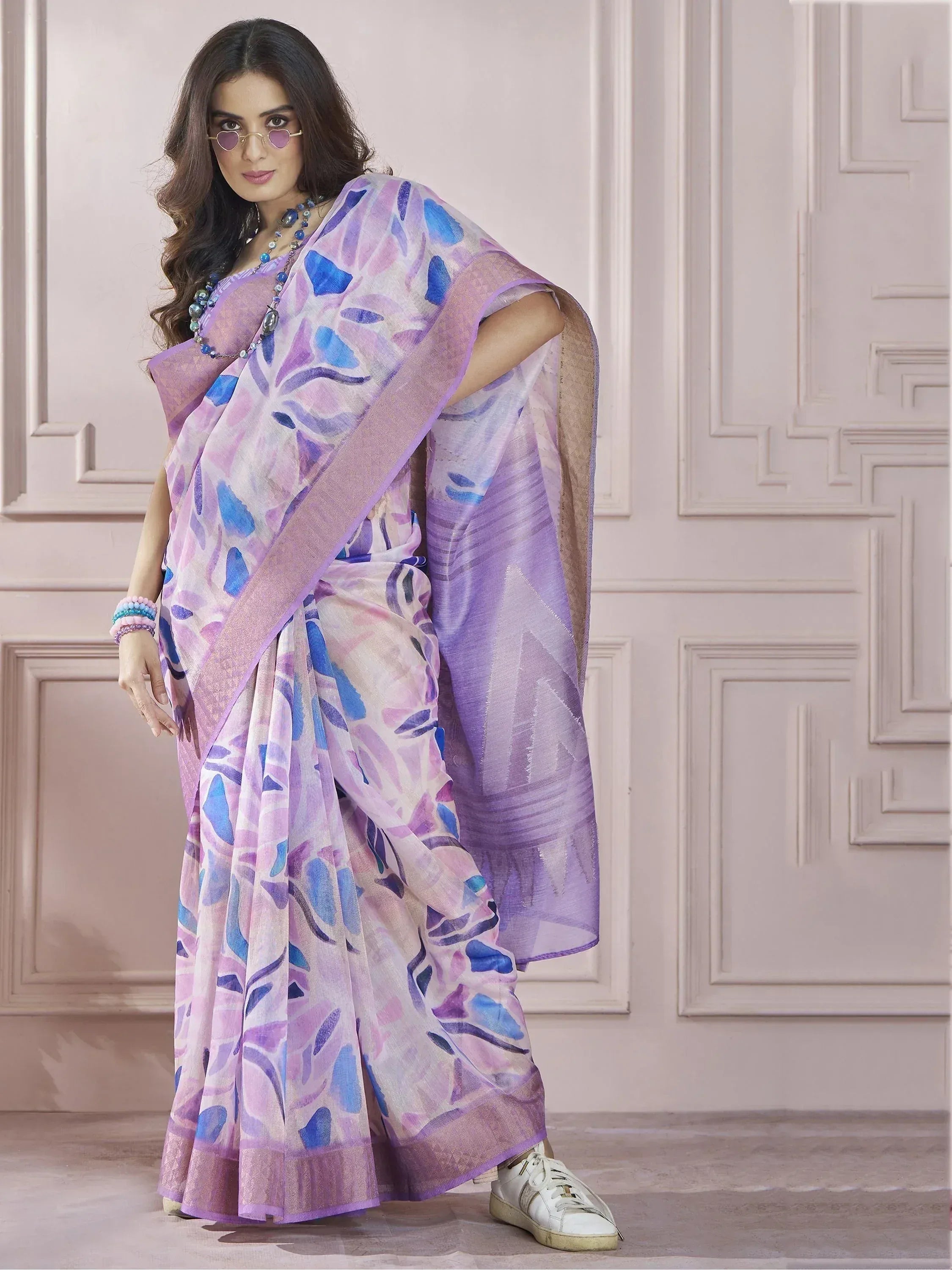 Woman in purple and blue floral print saree with modern sneakers, stylish ethnic wear