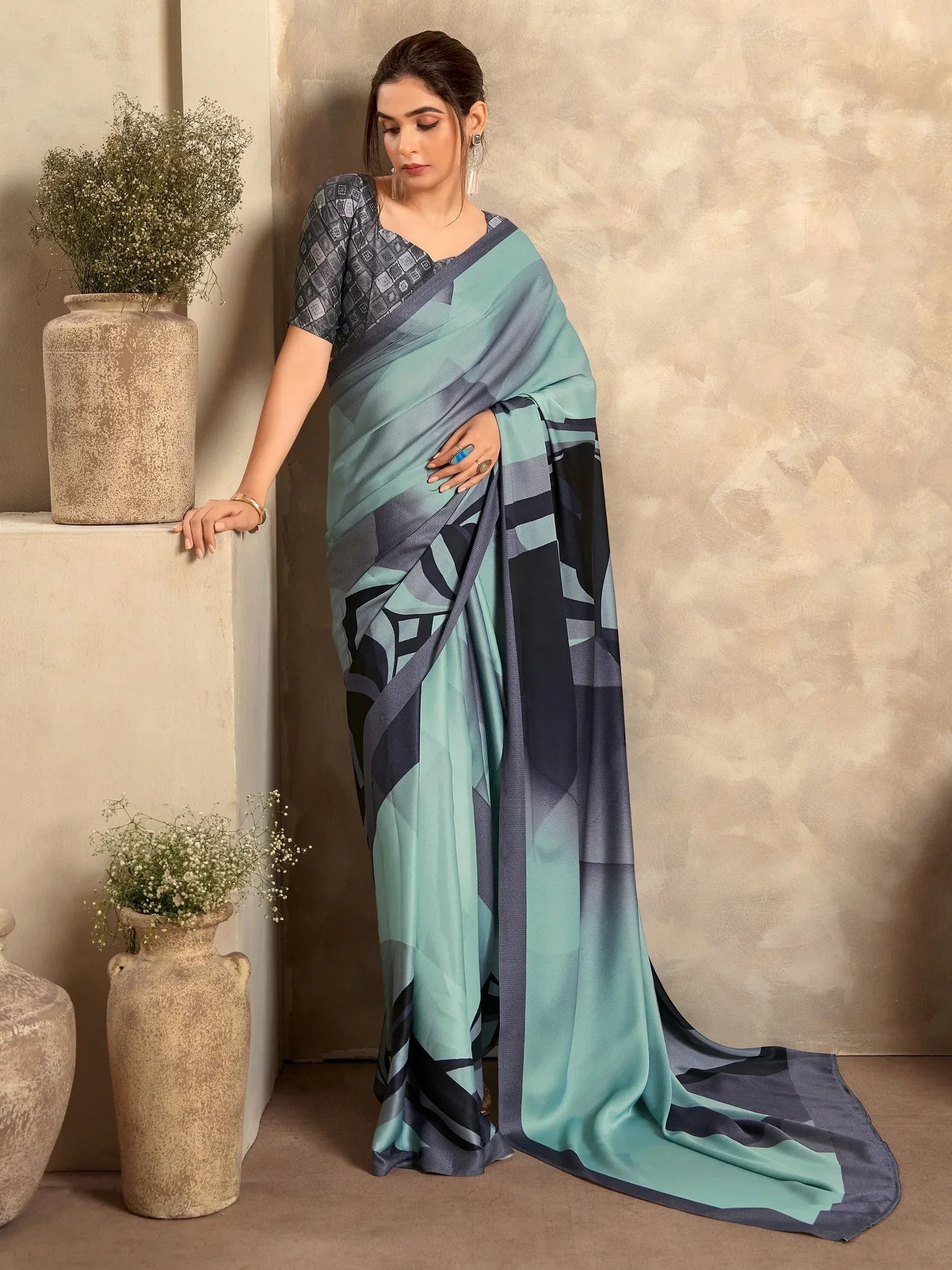 Woman in stylish teal and gray printed saree with geometric pattern, perfect for ethnic occasions