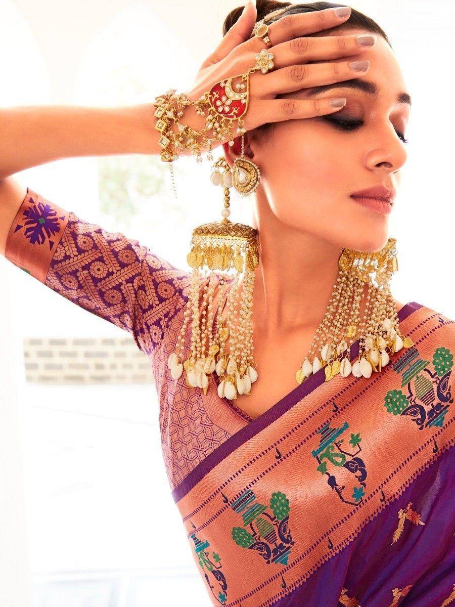 Woman in purple and peach printed saree with gold jewelry, showcasing ethnic Indian fashion