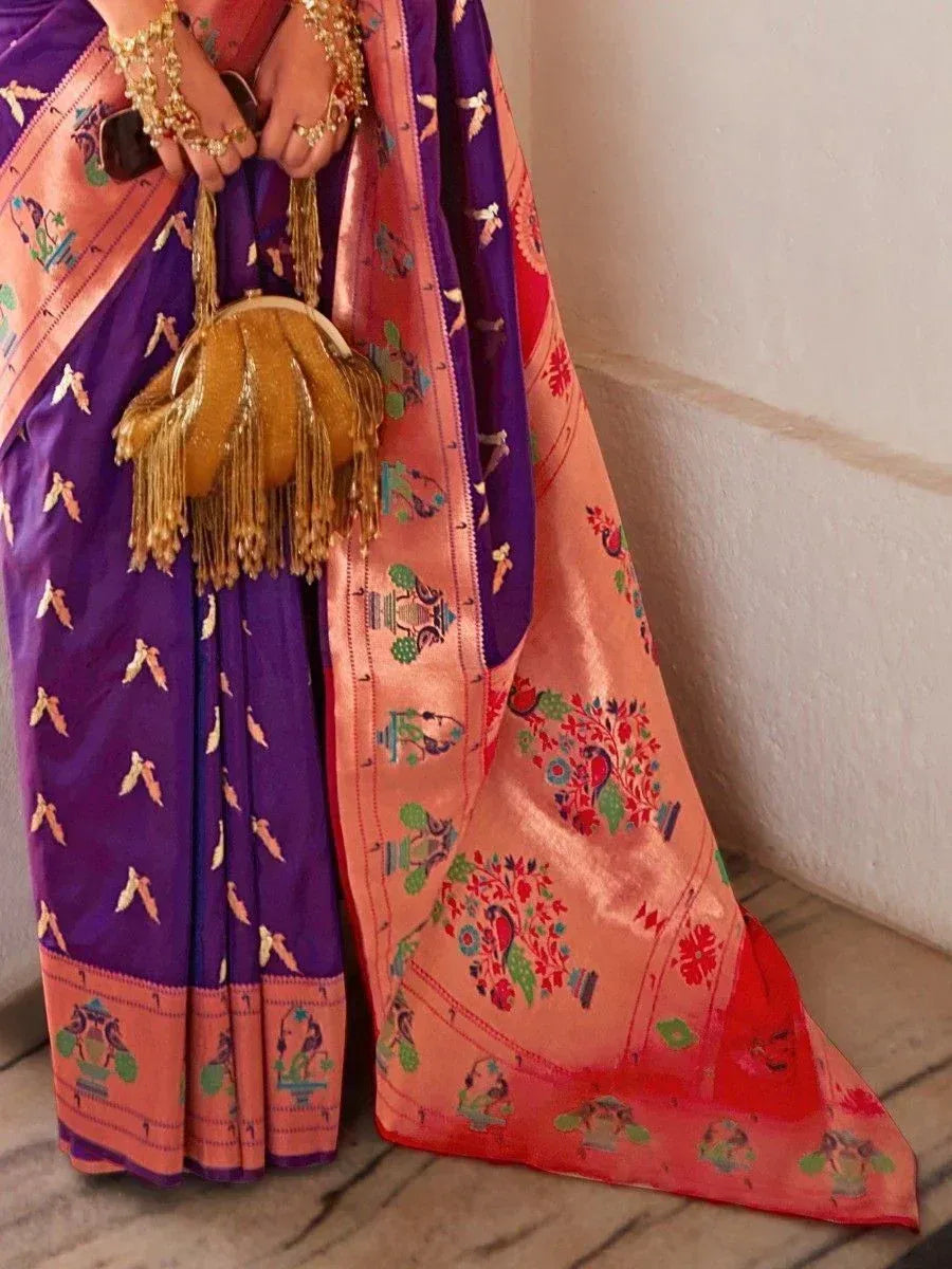 Purple and peach designer saree with peacock motifs, gold embroidery, and fringe clutch for ethnic wear