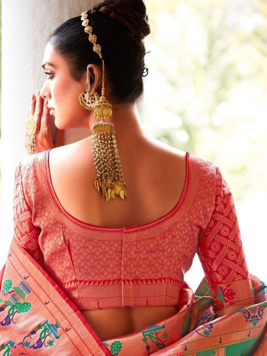 Woman in pink designer saree with gold jewelry, showcasing backless blouse and traditional Indian ethnic wear