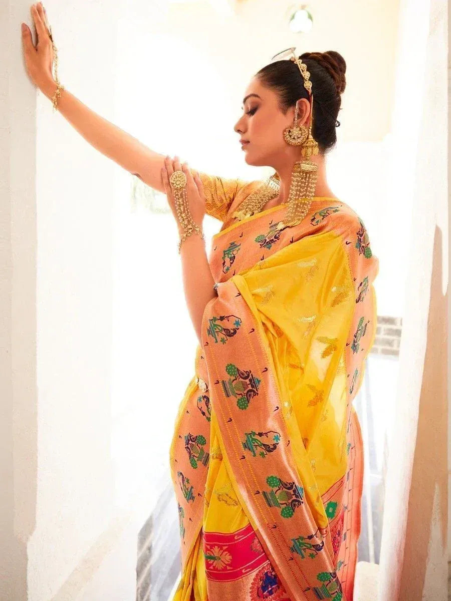 Woman in vibrant yellow and peach printed saree with traditional jewelry, showcasing ethnic Indian wear