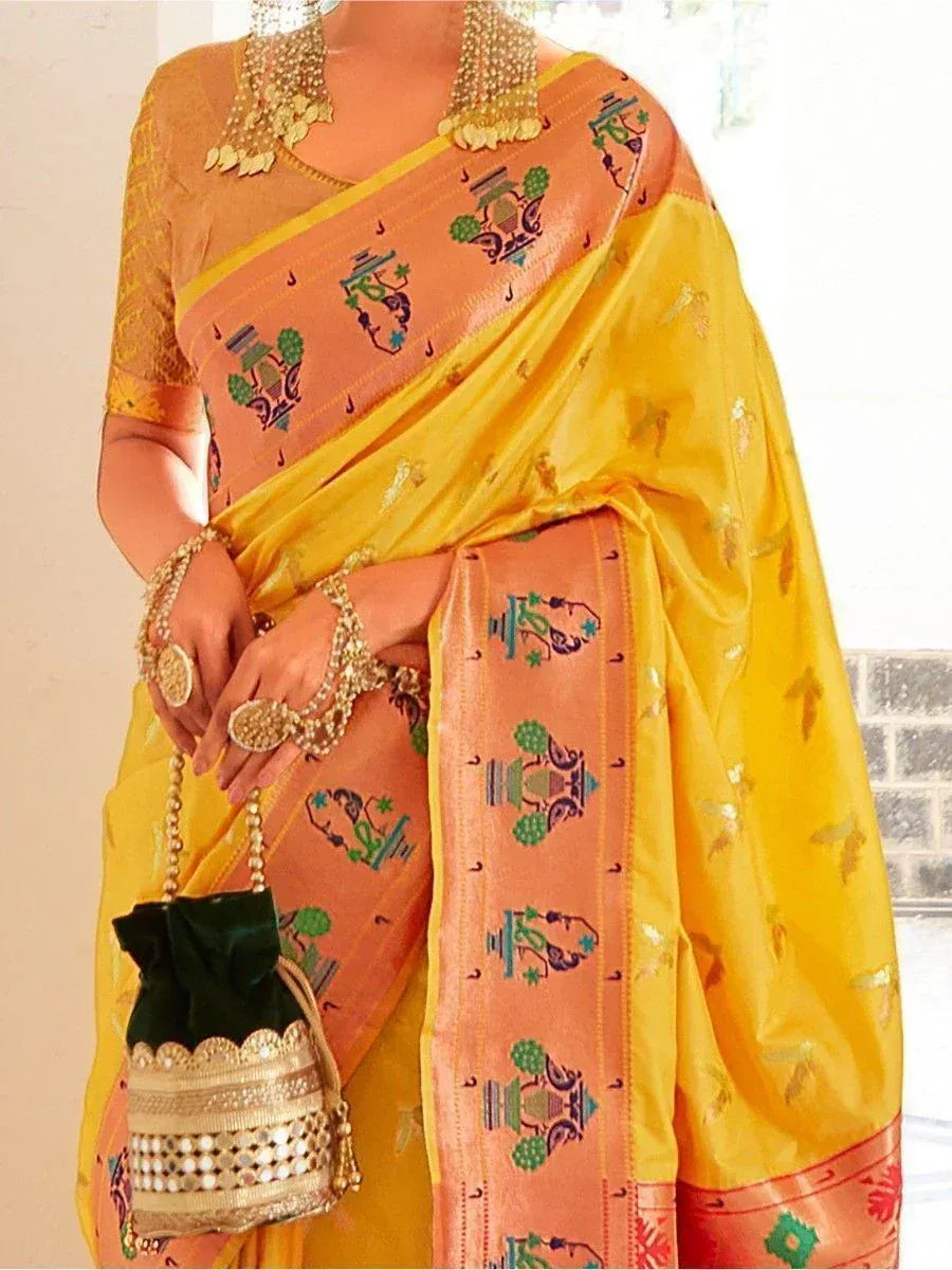 Yellow and peach saree with temple motifs, gold jewelry, and green potli bag for Indian ethnic wear