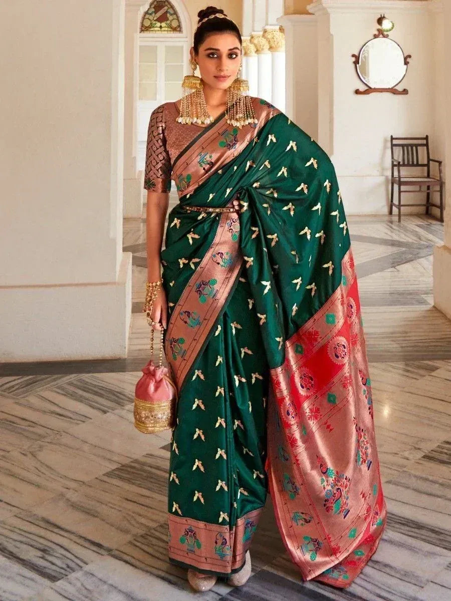 Elegant green silk saree with gold motifs and contrasting border, paired with blouse and traditional jewelry