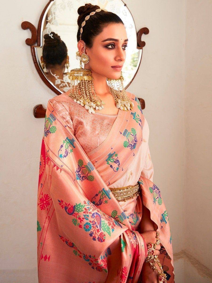 Woman in peach embroidered saree with gold jewelry, traditional Indian ethnic wear