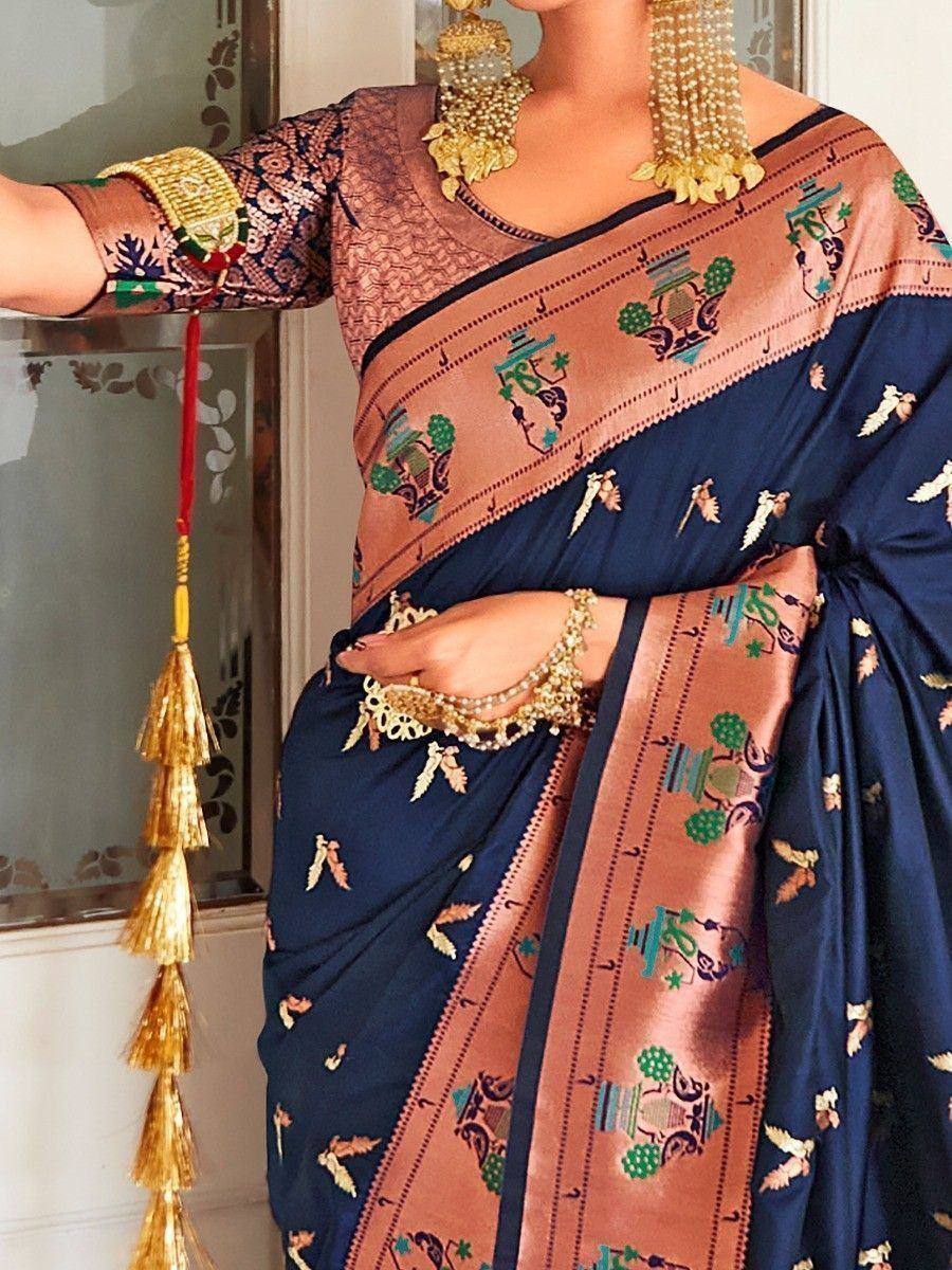 Navy blue saree with copper border, temple motifs, and gold jewelry for ethnic wear
