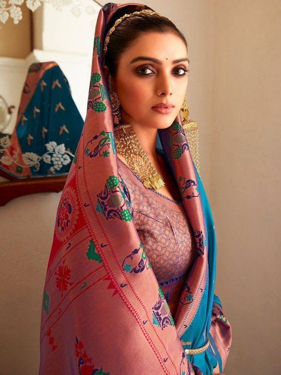 Woman in vibrant Indian ethnic saree with floral and elephant print, gold jewelry, traditional dupatta