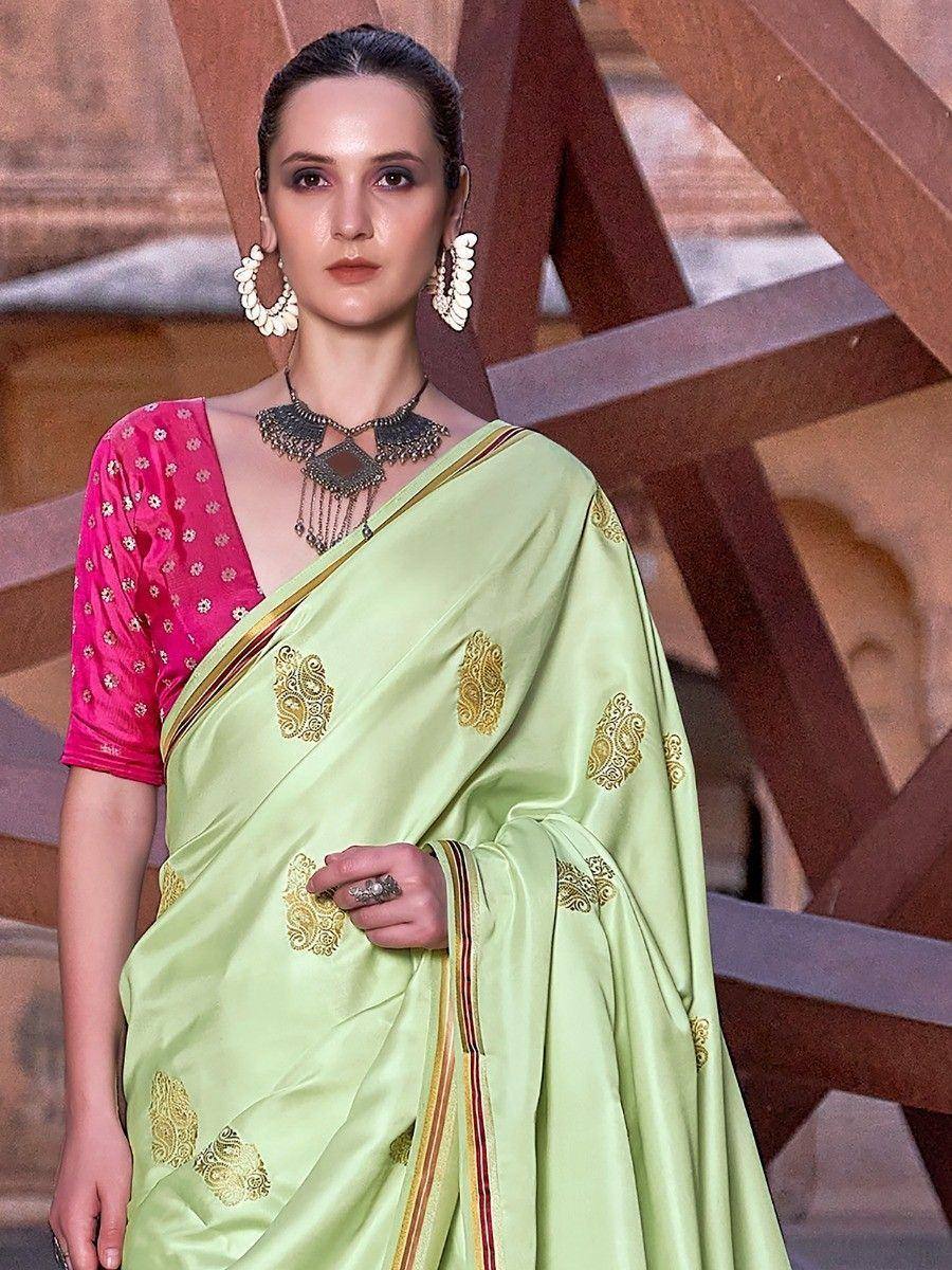 Light green silk saree with gold embroidery and pink blouse, styled with ethnic jewelry for Indian occasions