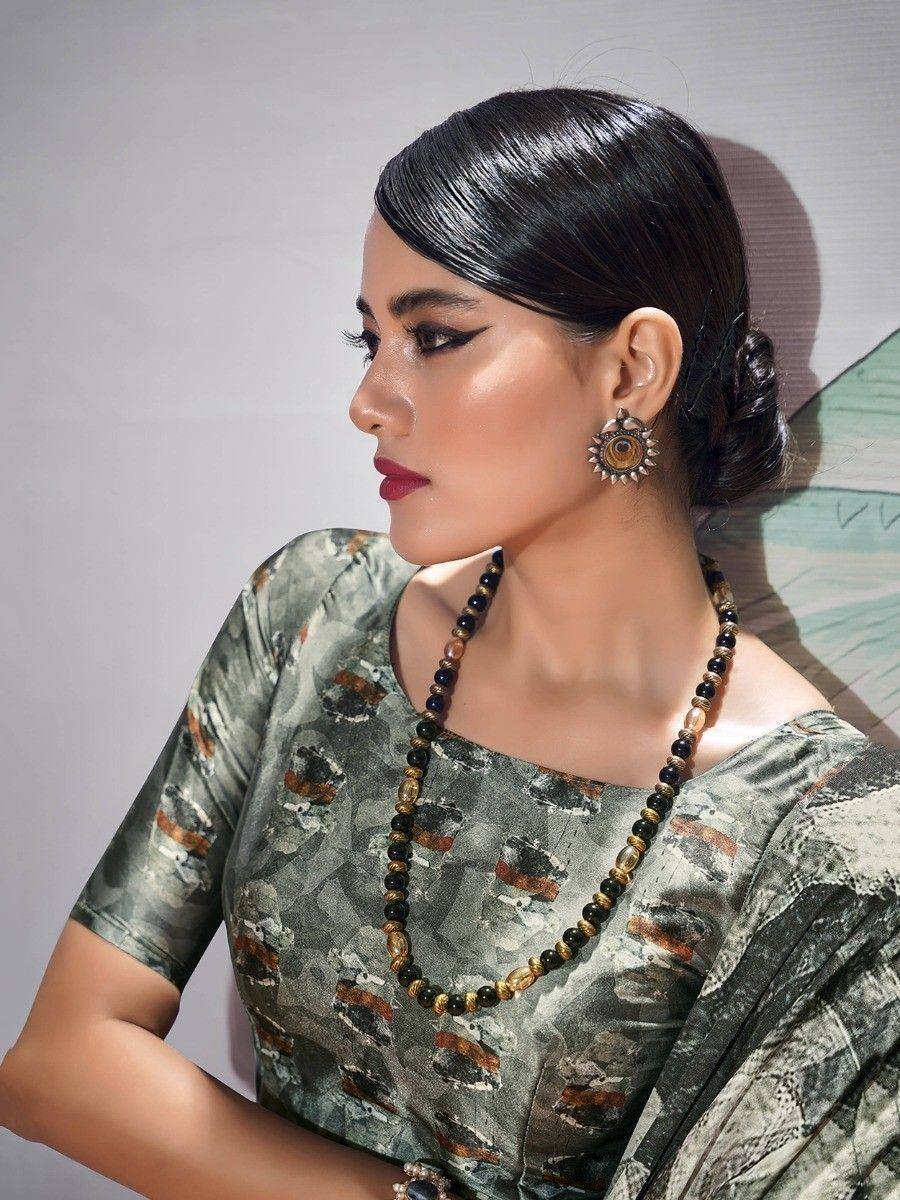 Woman in printed ethnic gown with statement necklace and earrings, showcasing Indian fashion