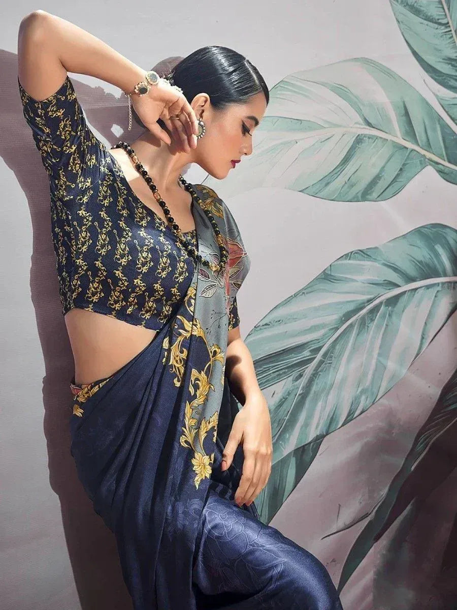 Elegant navy blue saree with gold floral print, paired with matching blouse and statement jewelry