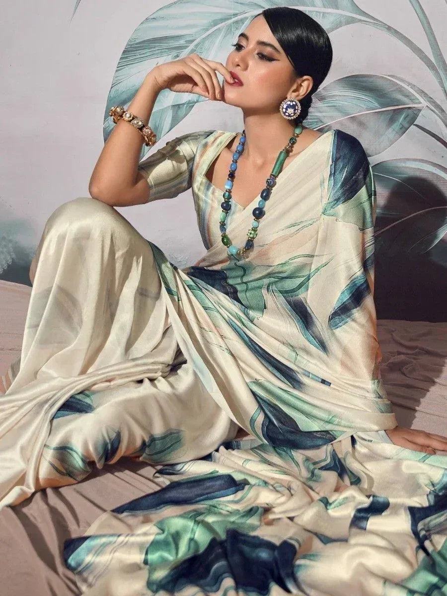 Elegant woman in designer saree with green and blue abstract print, styled with statement jewelry for ethnic wear.